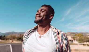 man facing the sun with a smile