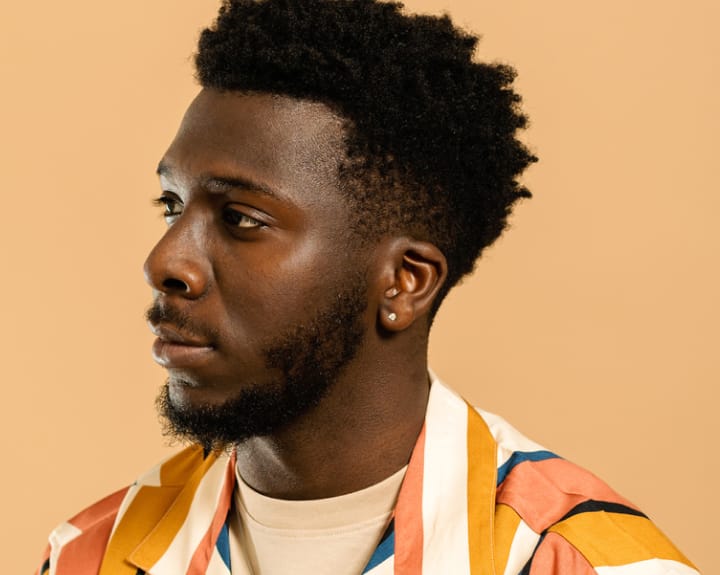 man with a beard and multi colored shirt