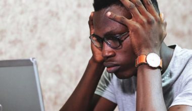 Man grabbing his head while looking at computer