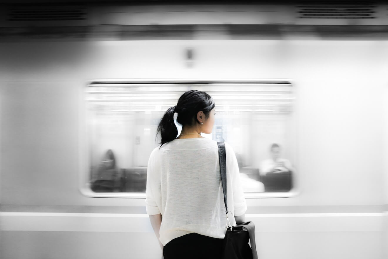 Woman in subway watching fast train go by