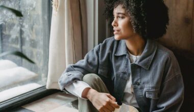 woman in blue jacket looking out window