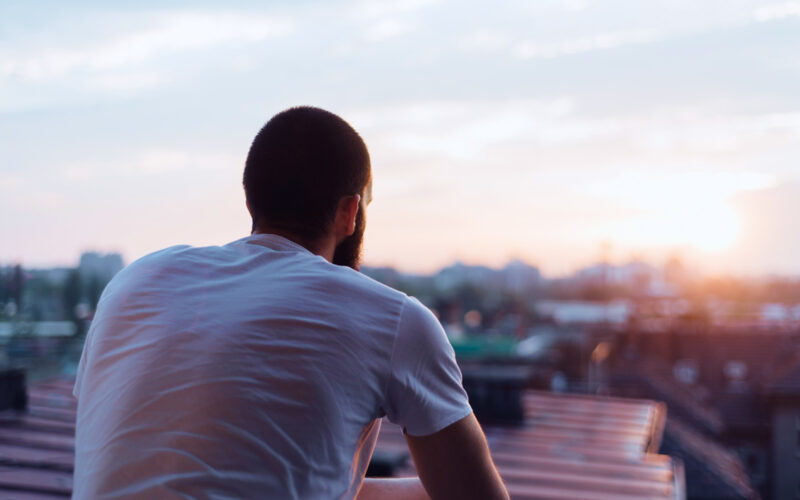 man sitting down facing away