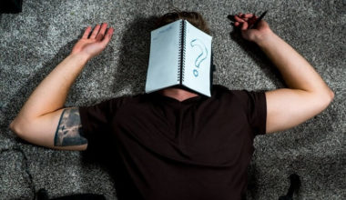 man in black shirt lying on floor