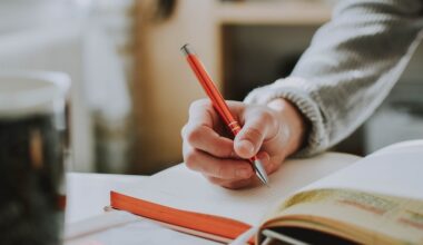 Person holding orange pen, journaling