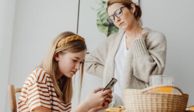 teenage girl using phone in front of mother