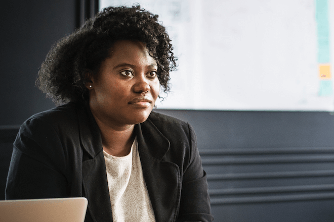 A woman sits confidently at a desk