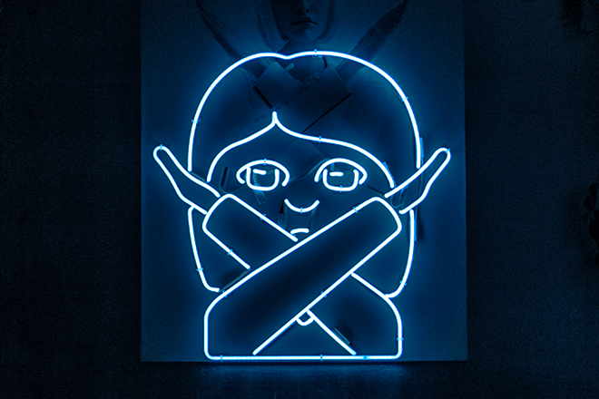 A neon "arms crossed" emoji